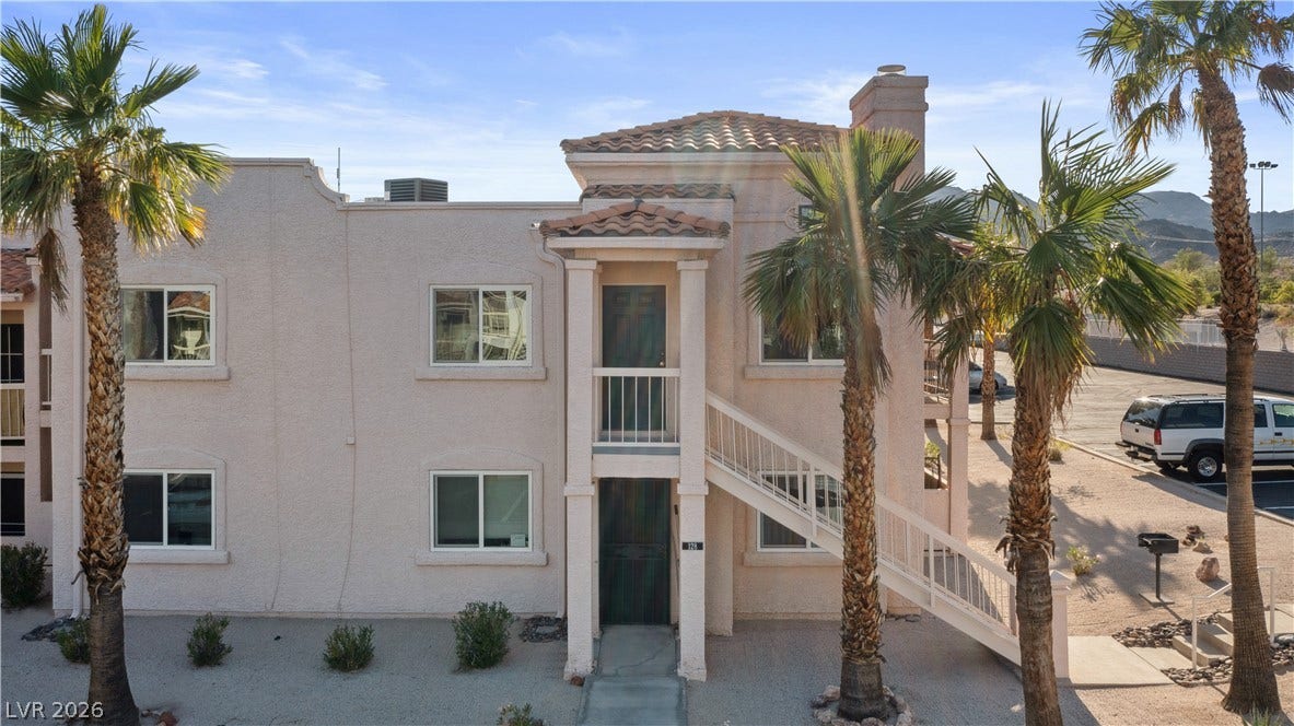 View of property with stairs, central AC unit, and a mountain view