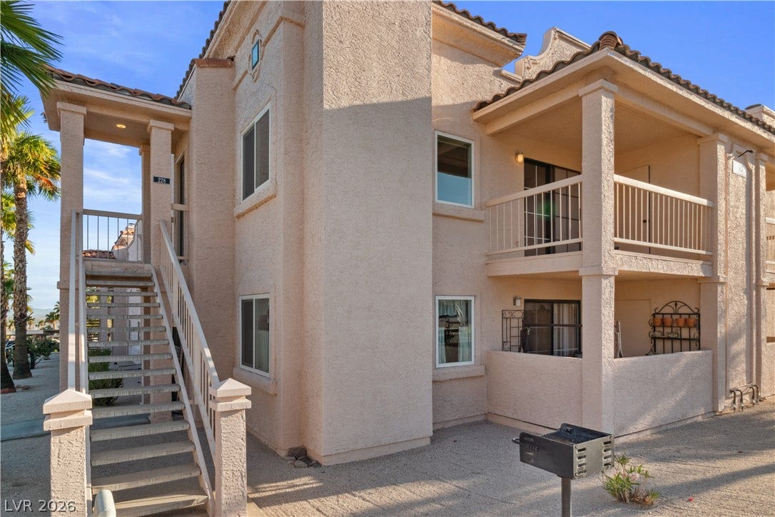 Front of the property, located on the second floor, with staircase to front door entry, also visible is the covered balcony that overlooks the local park