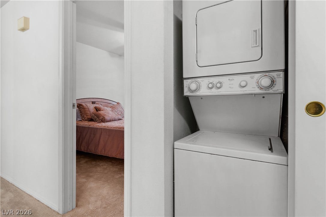 Laundry closet, located in the hallway featuring stacked washer / drying machine
