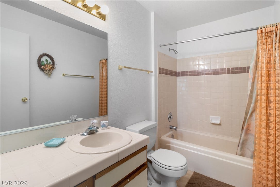 Full hallway bathroom featuring shower / bath combination with curtain, toilet, and vanity