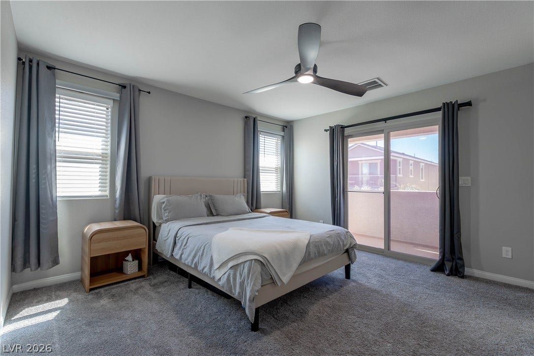 7061 Tilligerry Street, North Las Vegas, NV 89084 Sliding glass doors open to a private balcony from this spacious bedroom.