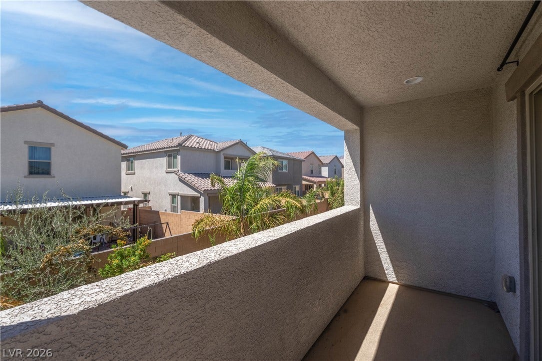 7061 Tilligerry Street, North Las Vegas, NV 89084 An elevated covered balcony overlooks the surrounding neighborhood yards under blue skies.