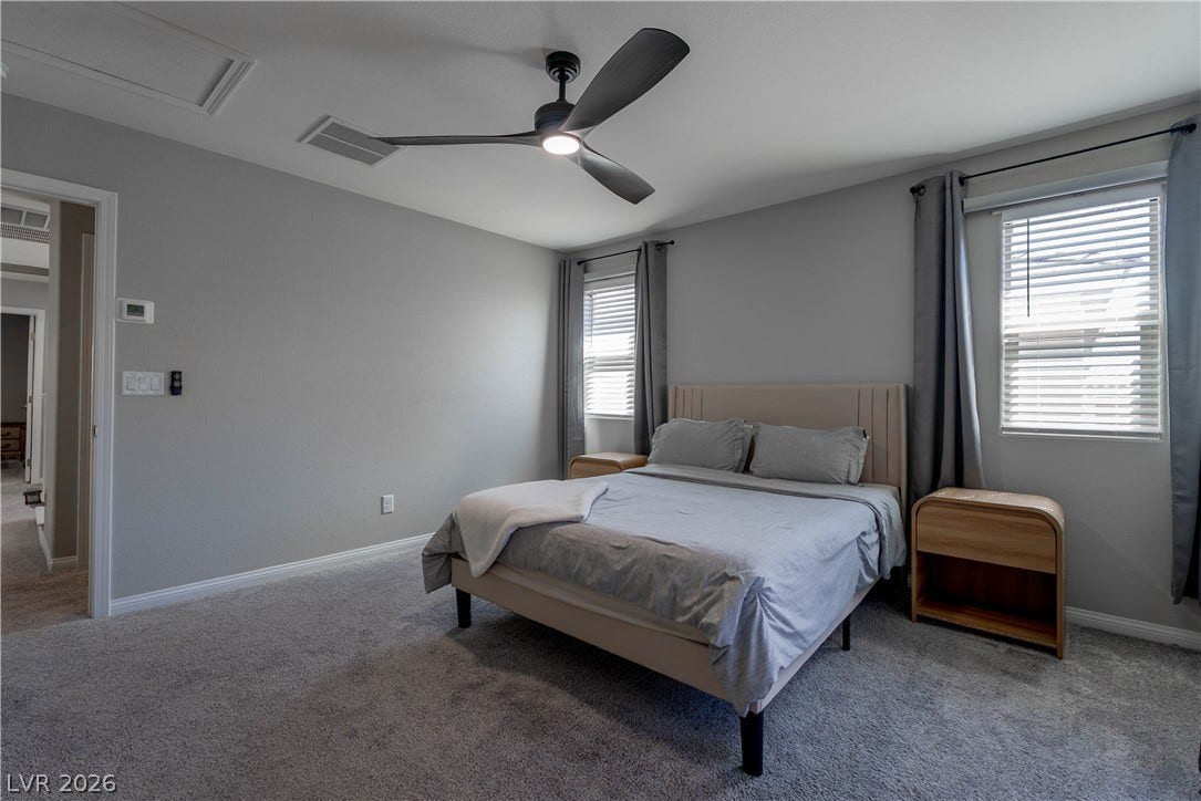 7061 Tilligerry Street, North Las Vegas, NV 89084 Plush carpeting and multiple windows create a comfortable and inviting atmosphere in this bedroom.