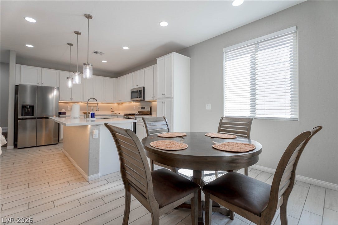 7061 Tilligerry Street, North Las Vegas, NV 89084 Gleaming quartz countertops and wood-look tile flooring elevate this modern culinary and dining space.