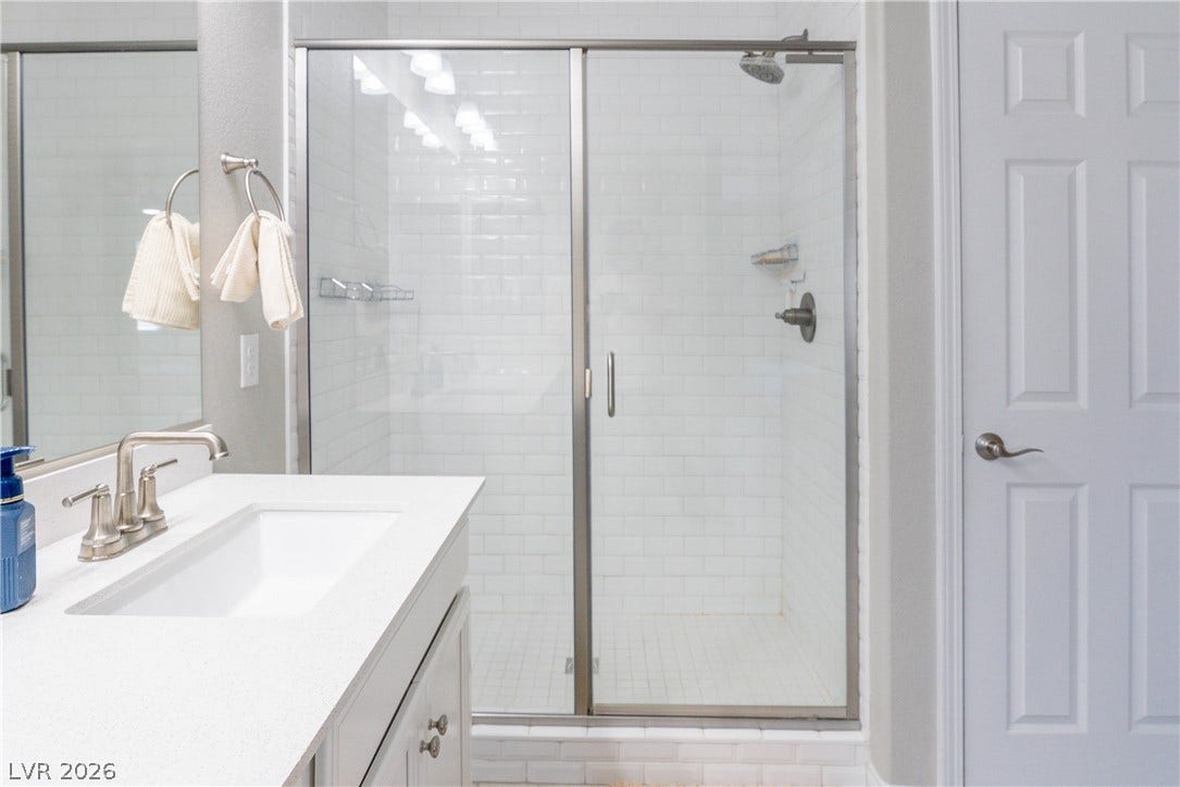 7061 Tilligerry Street, North Las Vegas, NV 89084 Walk-in shower adjacent to a quartz-topped vanity.