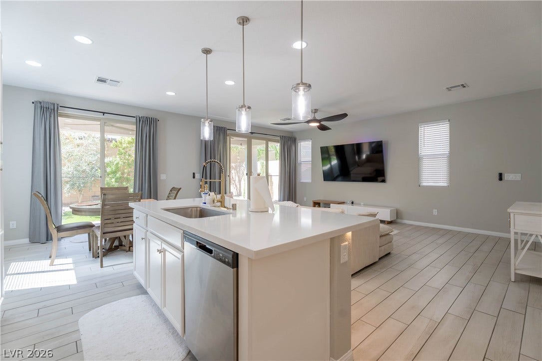 7061 Tilligerry Street, North Las Vegas, NV 89084 An open-concept layout connects the kitchen island to the living space with tiled flooring throughout.