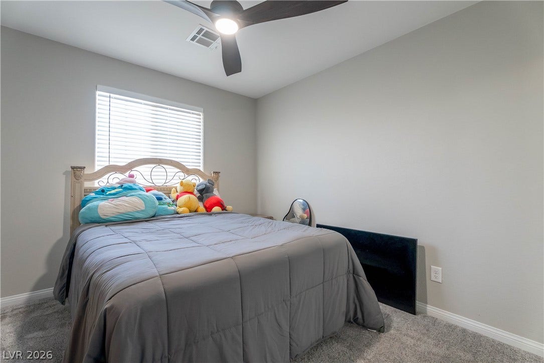7061 Tilligerry Street, North Las Vegas, NV 89084 Plush carpeting and classic baseboards anchor this comfortable secondary bedroom.