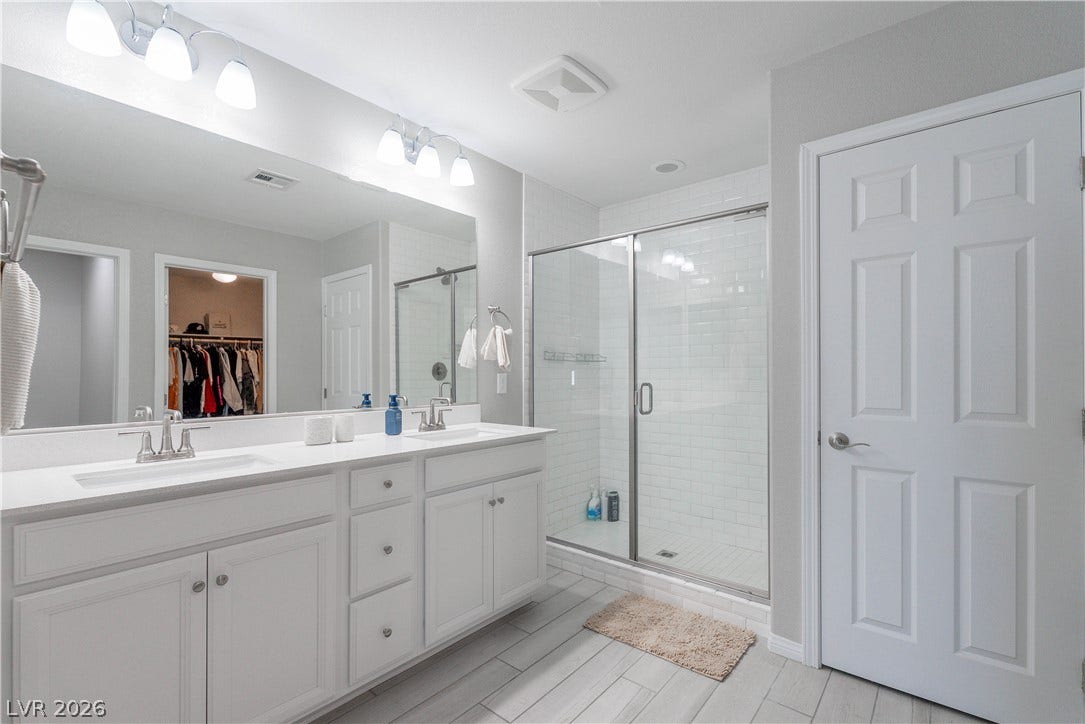 7061 Tilligerry Street, North Las Vegas, NV 89084 Clean lines and a spacious dual vanity define this modern primary bathroom.