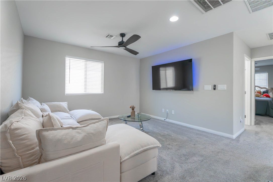 7061 Tilligerry Street, North Las Vegas, NV 89084 An inviting secondary living space showcases soft plush carpeting and smooth plaster walls.