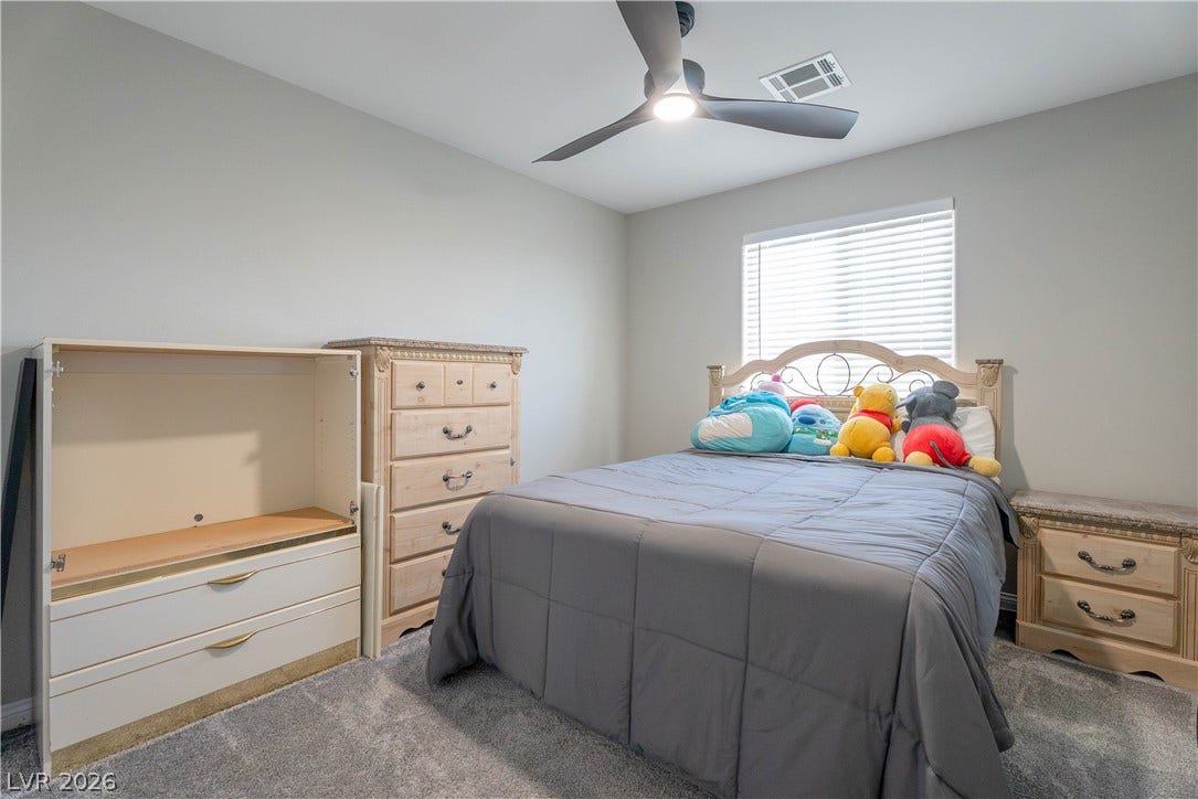 7061 Tilligerry Street, North Las Vegas, NV 89084 Plush carpeting and a large window create a comfortable, inviting atmosphere in this bedroom.