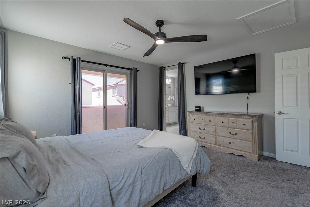 7061 Tilligerry Street, North Las Vegas, NV 89084 Sliding glass doors open to a private balcony in this comfortable bedroom space.