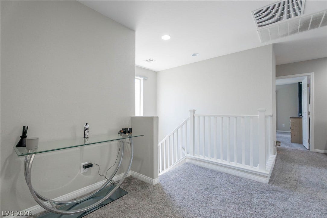 7061 Tilligerry Street, North Las Vegas, NV 89084 An open upper hallway features clean lines, plush carpeting, and a classic banister.