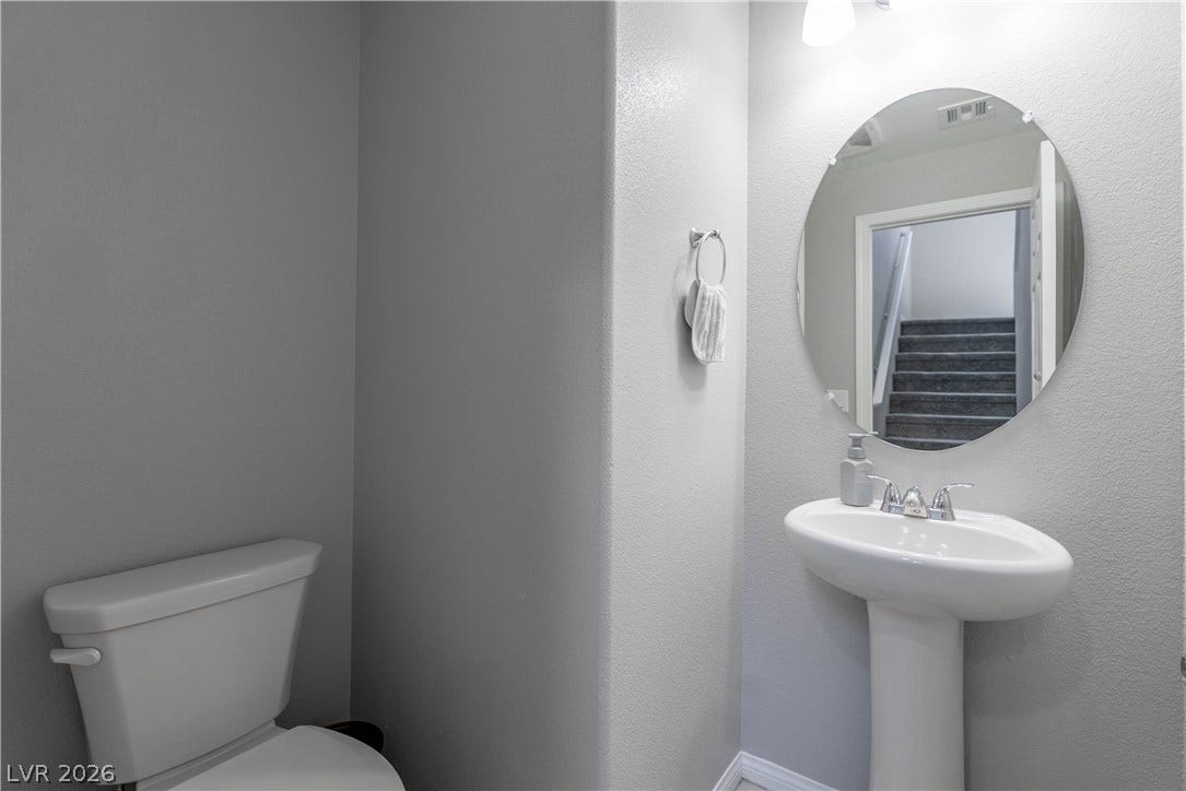 7061 Tilligerry Street, North Las Vegas, NV 89084 A classic pedestal sink and oval mirror anchor this efficiently designed powder room.