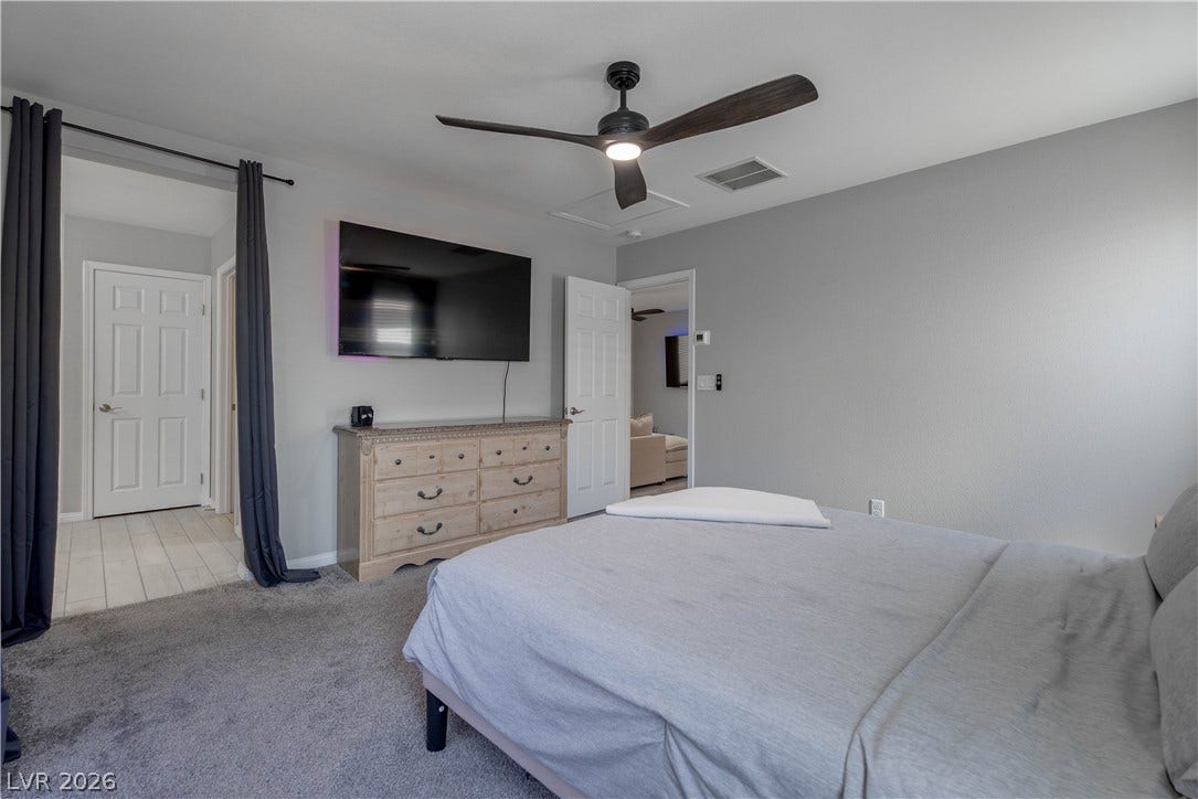 7061 Tilligerry Street, North Las Vegas, NV 89084 Plush carpeting anchors this comfortable bedroom suite featuring clean walls and classic panel doors.