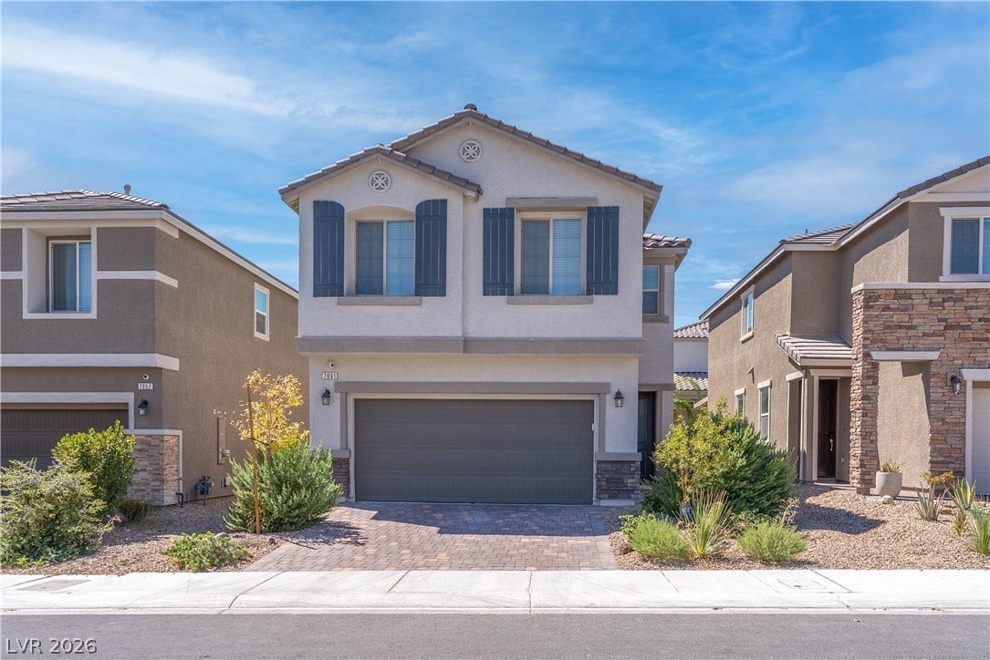 7061 Tilligerry Street, North Las Vegas, NV 89084 A classic stucco exterior pairs with a tiled roof and a paved driveway entry.
