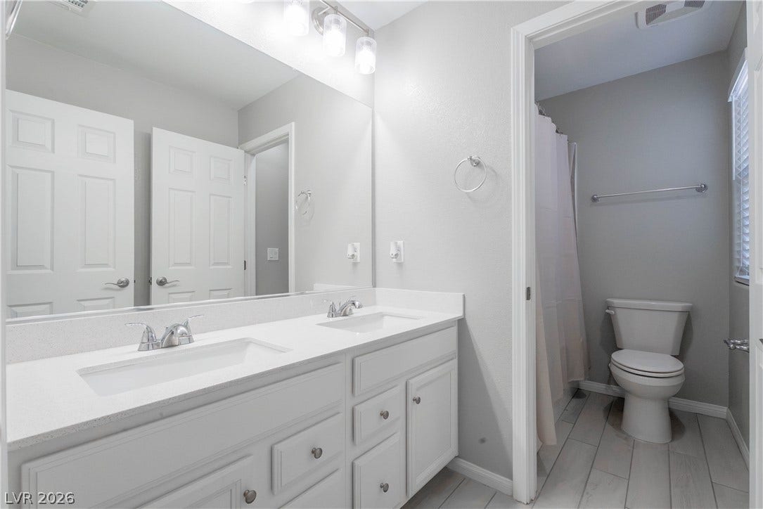 7061 Tilligerry Street, North Las Vegas, NV 89084 A spacious double vanity pairs with clean tile flooring in this classic bathroom design.