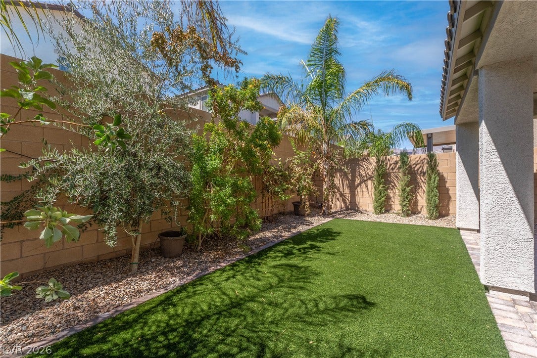 7061 Tilligerry Street, North Las Vegas, NV 89084 Mature palms and a tidy lawn frame this private, wall-enclosed outdoor space.