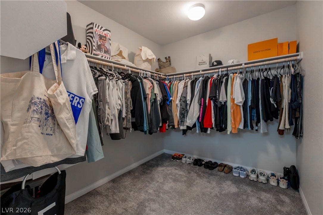 7061 Tilligerry Street, North Las Vegas, NV 89084 Ample hanging rods and overhead shelving maximize organization in this plushly carpeted walk-in closet.
