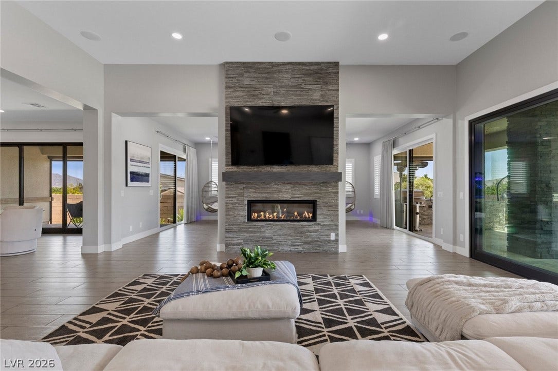9841 W El Campo Grande Avenue, Las Vegas, NV 89149 An inviting family room showcasing a captivating linear fireplace with stone surround.