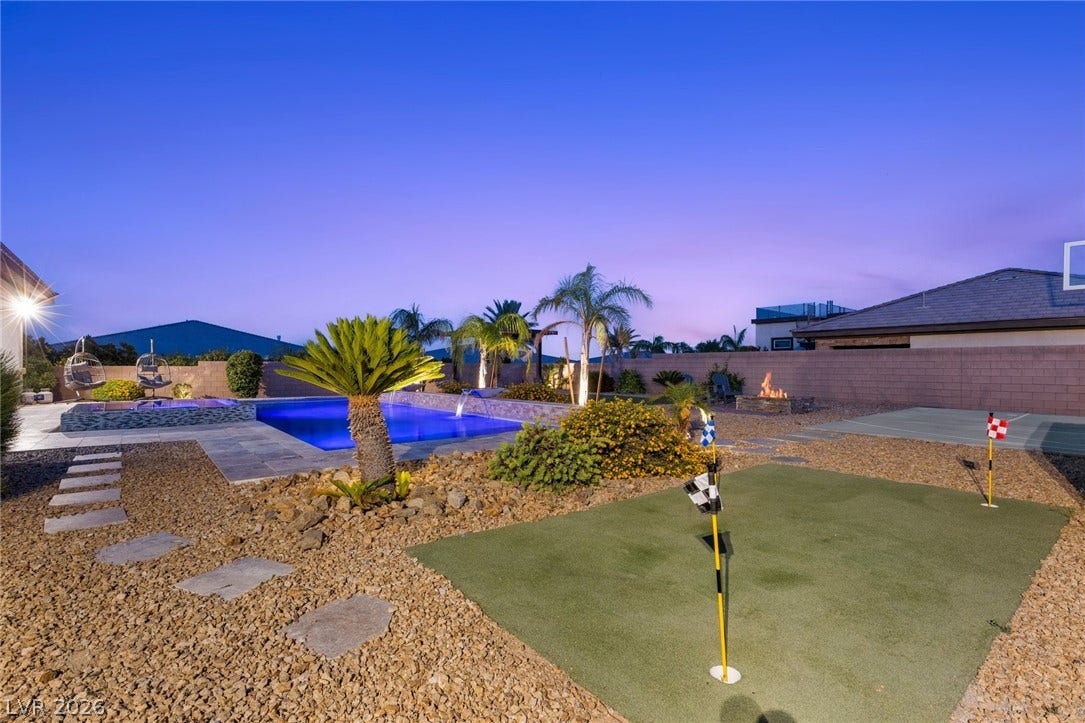 9841 W El Campo Grande Avenue, Las Vegas, NV 89149 An illuminated backyard retreat with a glistening pool and personal putting green.