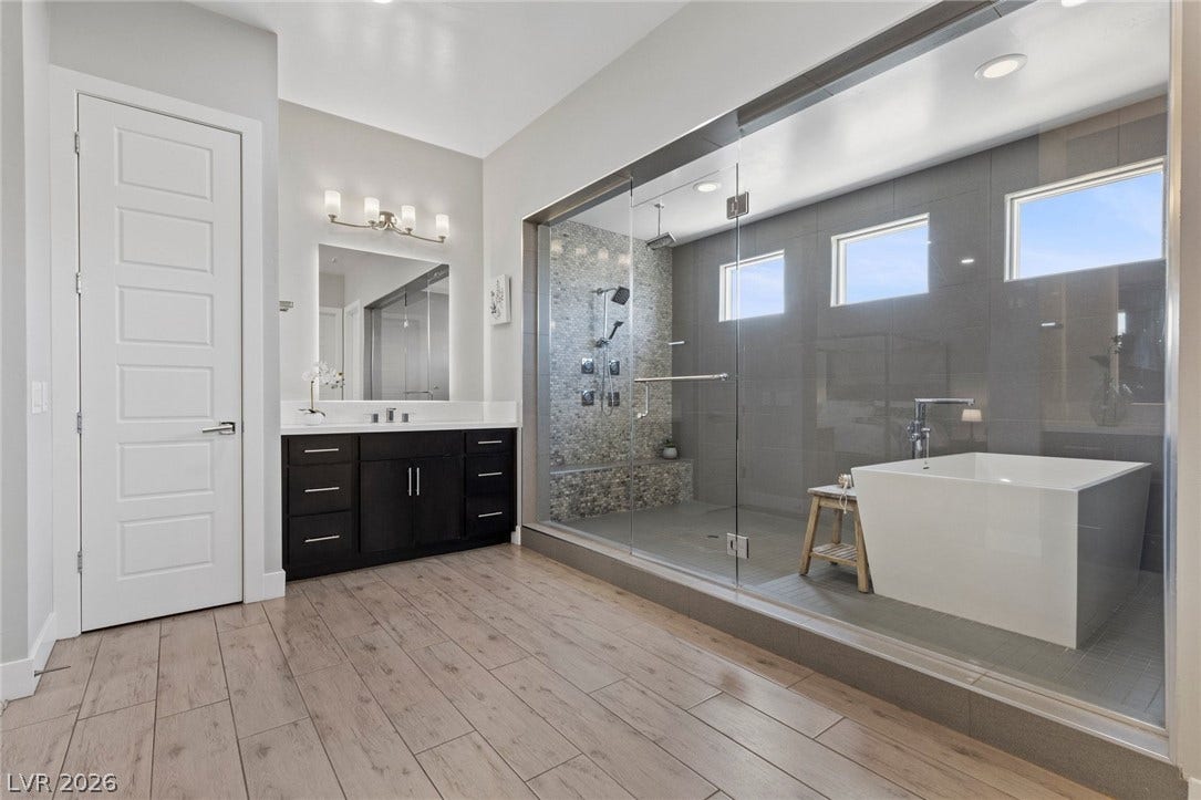 9841 W El Campo Grande Avenue, Las Vegas, NV 89149 Modern primary bathroom featuring a spacious glass-enclosed shower, freestanding tub, and a vanity with abundant storage.