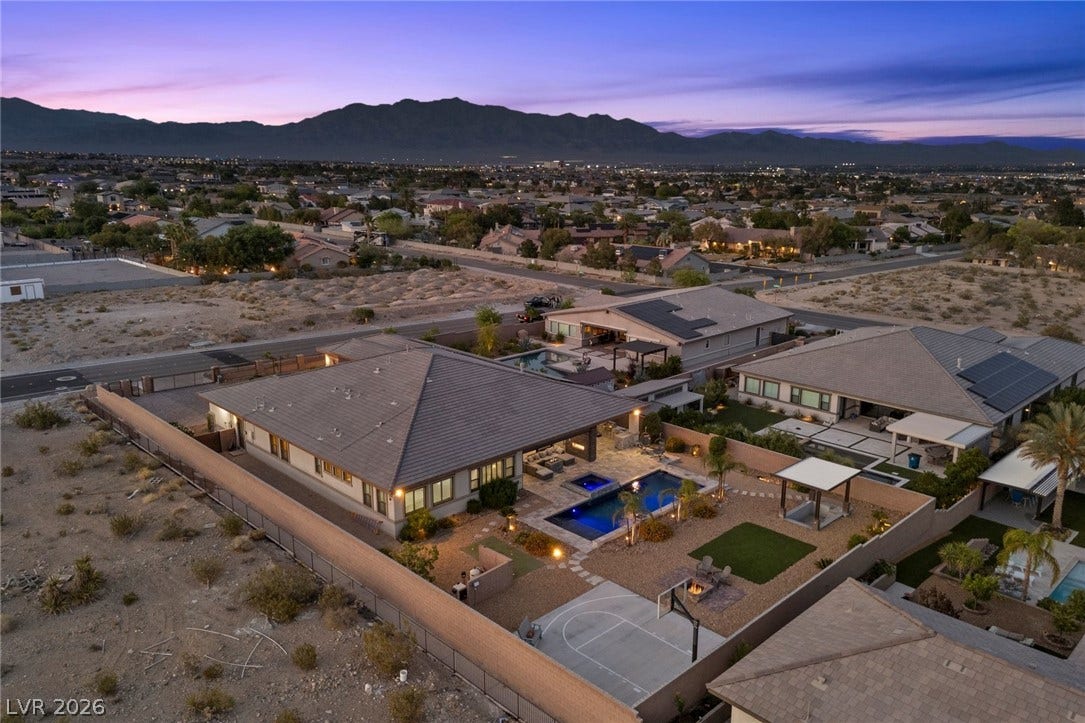 9841 W El Campo Grande Avenue, Las Vegas, NV 89149 An aerial perspective reveals a private oasis, blending mountain views with desert landscaping and vibrant pool.