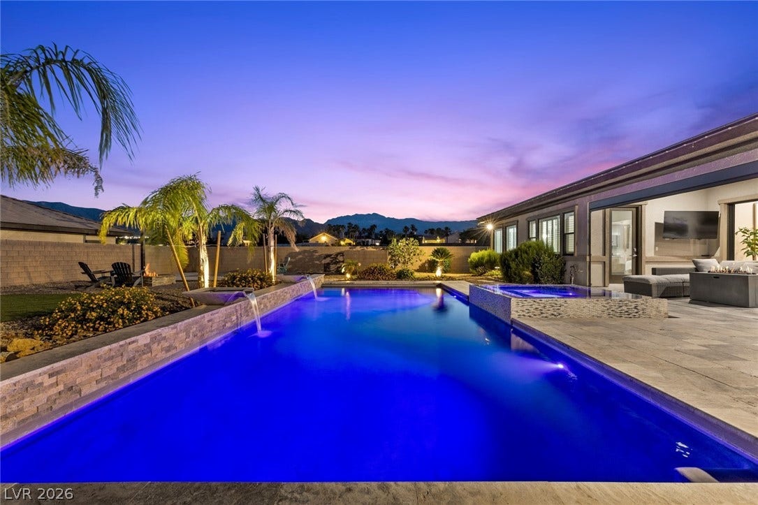 9841 W El Campo Grande Avenue, Las Vegas, NV 89149 An inviting backyard oasis features a shimmering pool with integrated spa and majestic mountain views at dusk.
