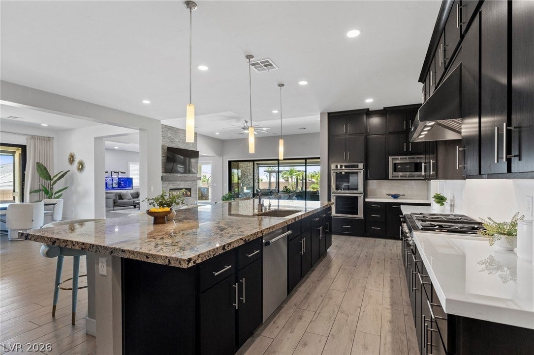 9841 W El Campo Grande Avenue, Las Vegas, NV 89149 An open-concept kitchen with a substantial island flows seamlessly into the living space and outdoor patio.