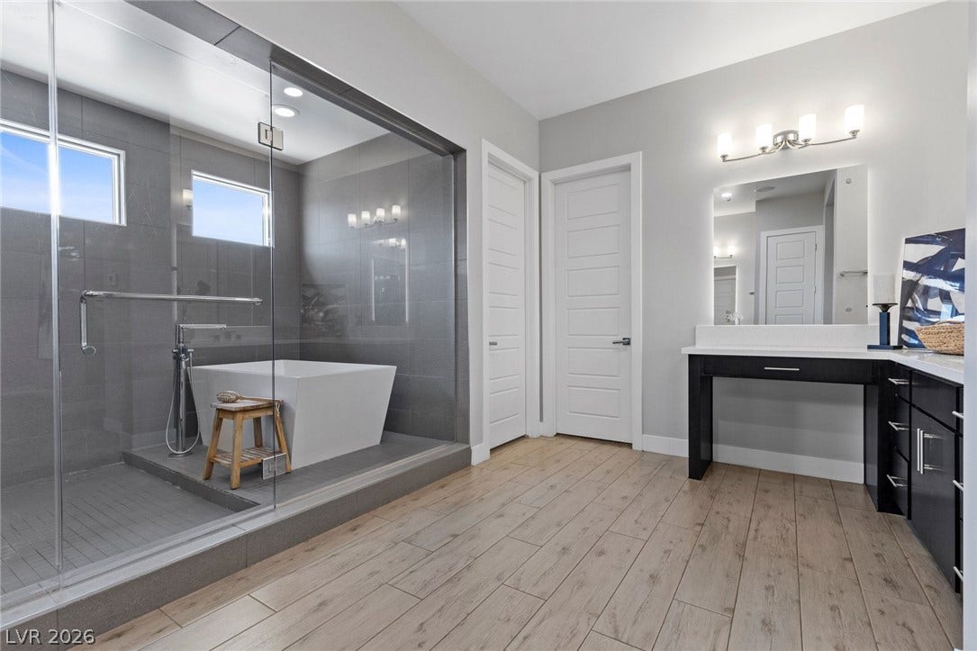 9841 W El Campo Grande Avenue, Las Vegas, NV 89149 Luxurious bathing retreat featuring a spacious walk-in shower and a standalone soaking tub.