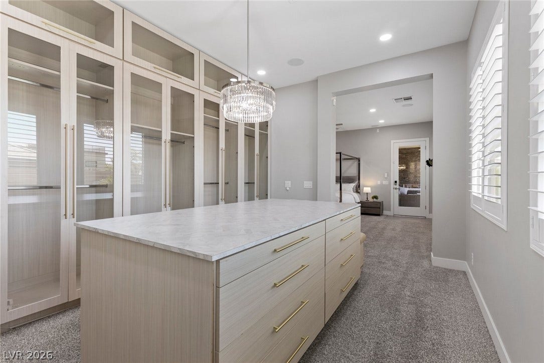 9841 W El Campo Grande Avenue, Las Vegas, NV 89149 A capacious walk-in closet with an ample central island, ideal for organizing your wardrobe.