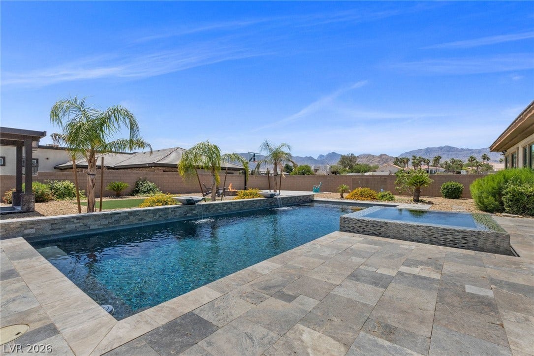 9841 W El Campo Grande Avenue, Las Vegas, NV 89149 An inviting backyard oasis offers a sparkling pool and spa, perfect for relaxation or entertaining.