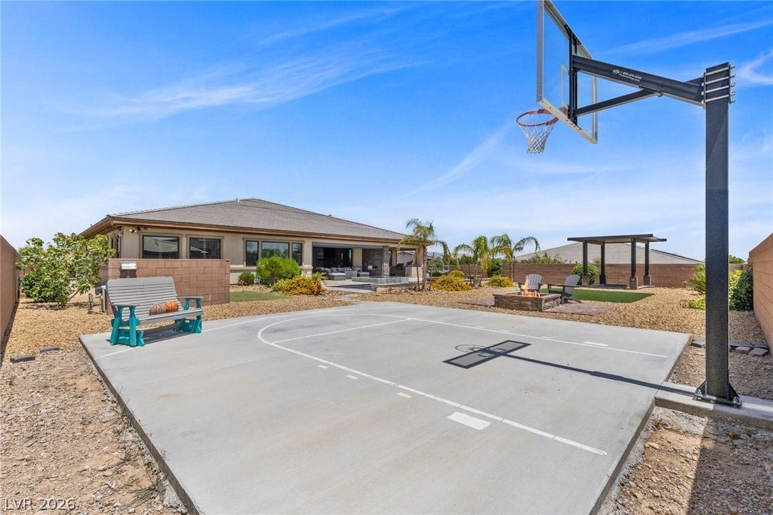 9841 W El Campo Grande Avenue, Las Vegas, NV 89149 A spacious backyard retreat features a half basketball court, fire pit, and ample space for entertaining.