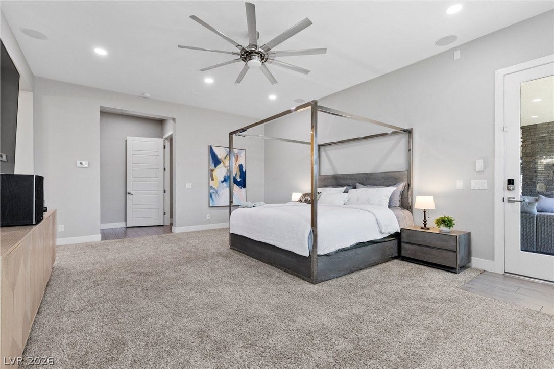 9841 W El Campo Grande Avenue, Las Vegas, NV 89149 An inviting bedroom features a large bed and a sleek ceiling fan for ultimate comfort.