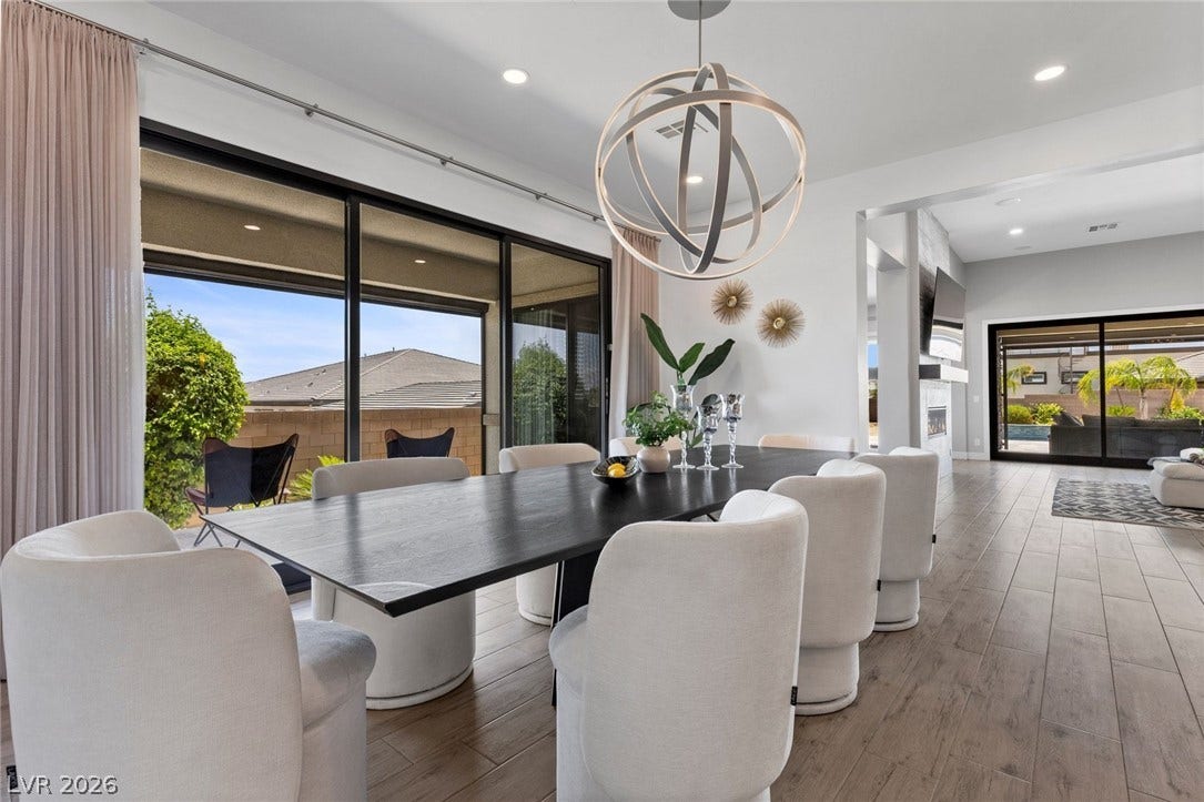 9841 W El Campo Grande Avenue, Las Vegas, NV 89149 A well-lit dining area featuring a contemporary chandelier and large sliding glass doors.