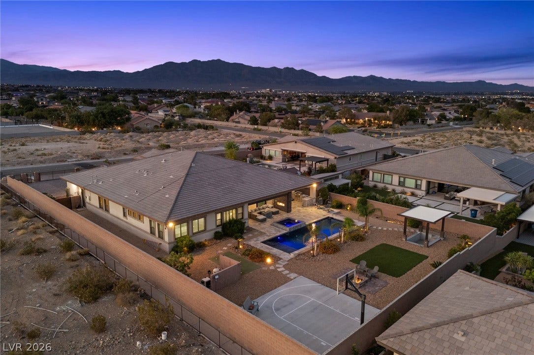 9841 W El Campo Grande Avenue, Las Vegas, NV 89149 An aerial view showcases a meticulously designed desert oasis with a sparkling pool and recreational court.