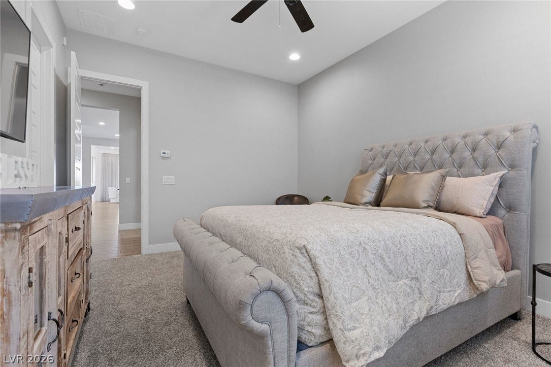 9841 W El Campo Grande Avenue, Las Vegas, NV 89149 Relax in this tranquil bedroom, featuring plush carpeting and soft lighting.