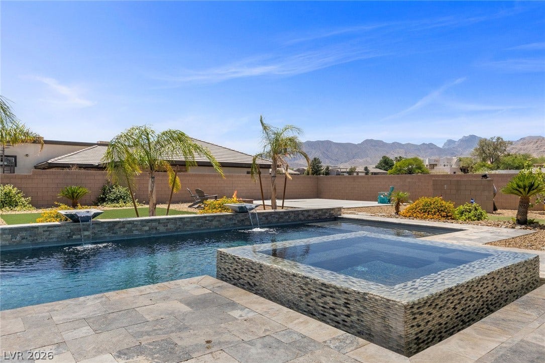 9841 W El Campo Grande Avenue, Las Vegas, NV 89149 A private backyard oasis features a glistening pool and spa with mountain vistas.