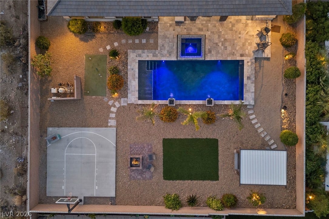 9841 W El Campo Grande Avenue, Las Vegas, NV 89149 An aerial perspective reveals a luxurious backyard oasis, complete with a luminous pool, spa, and multiple entertainment zones.