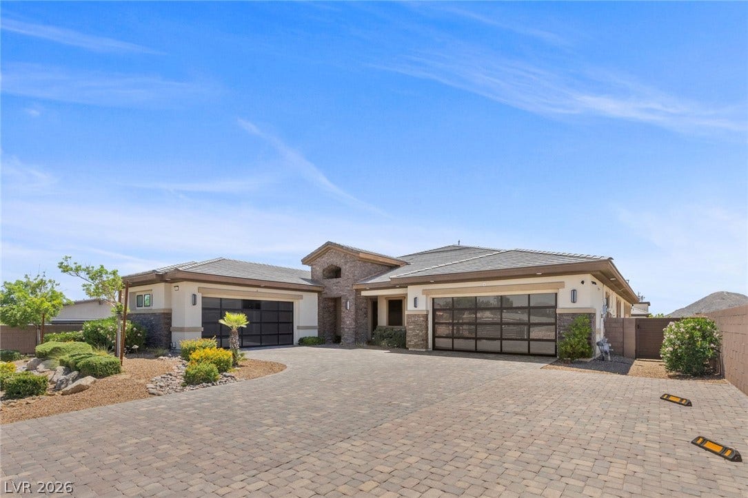 9841 W El Campo Grande Avenue, Las Vegas, NV 89149 A grand entrance with paver driveway and dual modern garage doors welcomes you to this desert oasis.
