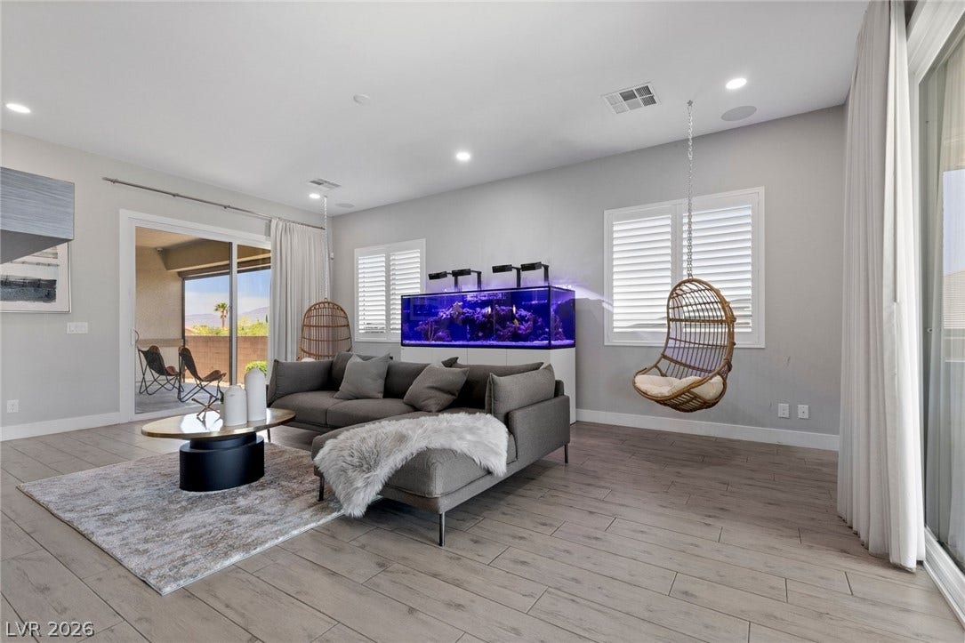 9841 W El Campo Grande Avenue, Las Vegas, NV 89149 Sliding glass doors reveal an inviting patio, complementing the spacious, naturally illuminated living area.