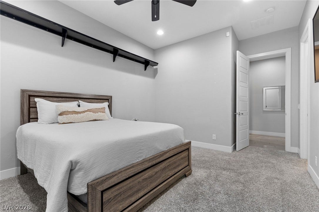9841 W El Campo Grande Avenue, Las Vegas, NV 89149 A well-lit bedroom with plush carpeting offers a cozy retreat.