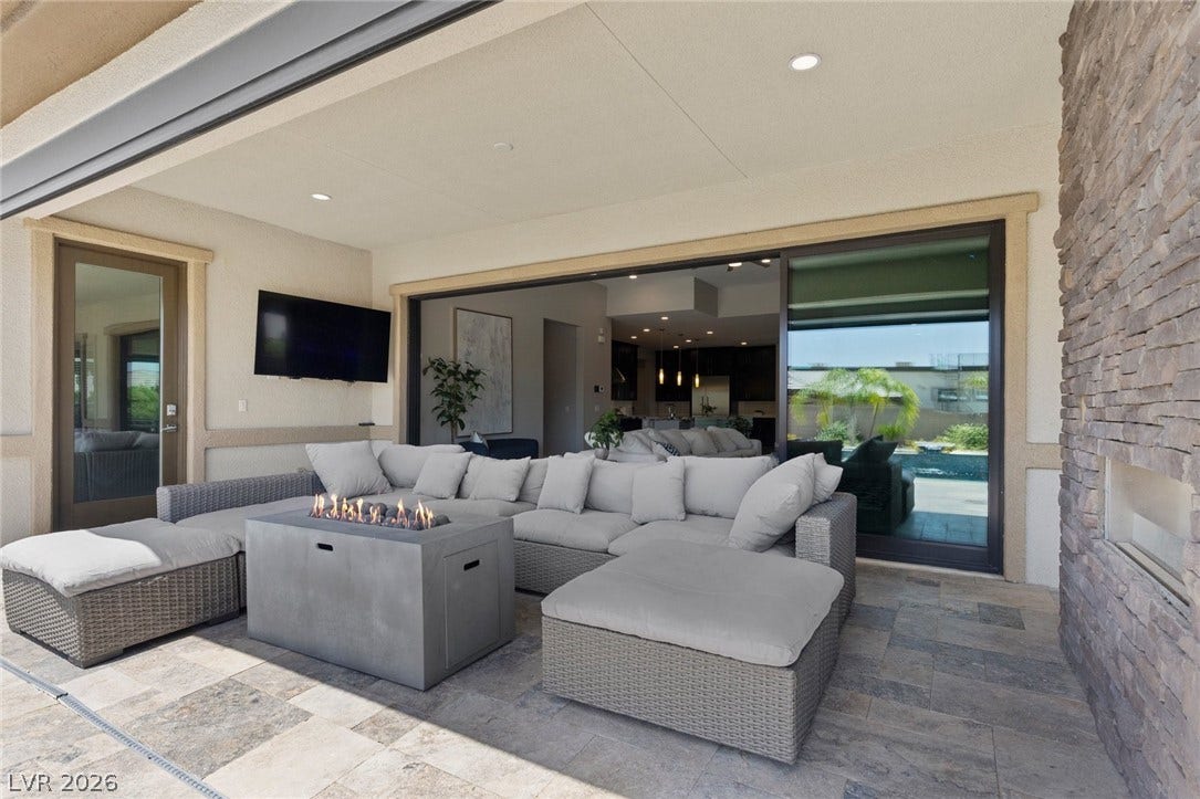 9841 W El Campo Grande Avenue, Las Vegas, NV 89149 An inviting outdoor living space features a cozy seating area and a modern fire pit, perfect for evening gatherings.