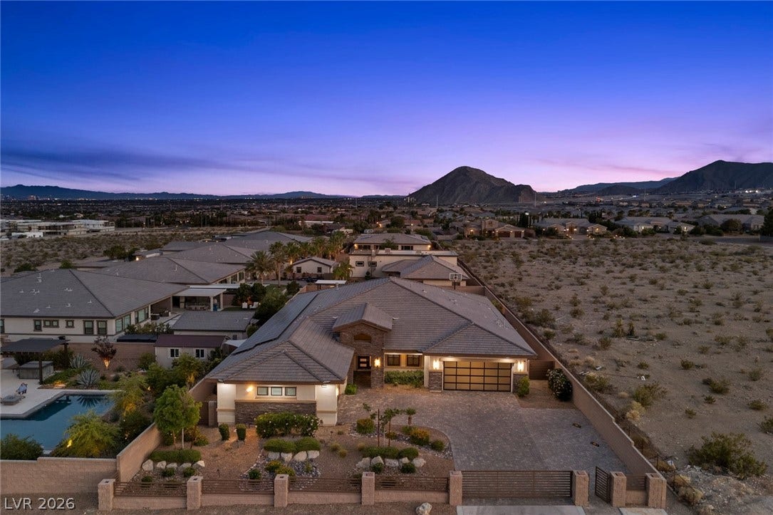 9841 W El Campo Grande Avenue, Las Vegas, NV 89149 An aerial perspective reveals this captivating residence with a sparkling pool and desert landscaping, framed by distant mountains.
