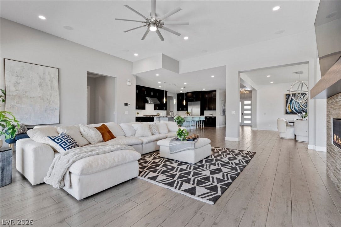 9841 W El Campo Grande Avenue, Las Vegas, NV 89149 An inviting open-concept living space features a cozy seating area and a modern kitchen beyond.