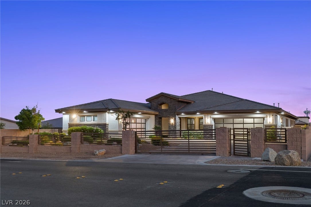 9841 W El Campo Grande Avenue, Las Vegas, NV 89149 Elegant fencing and automatic gates enhance the private yard, framing this distinguished residence.
