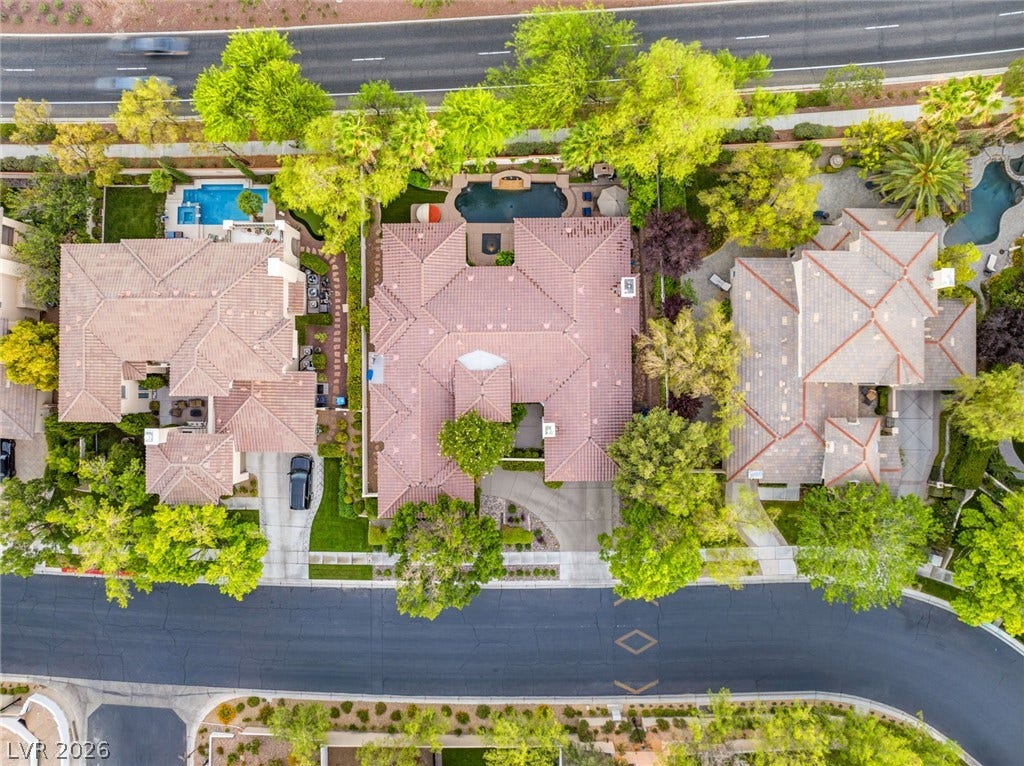 An aerial perspective showcases the tiled rooflines, private swimming pool, and manicured neighborhood landscaping.