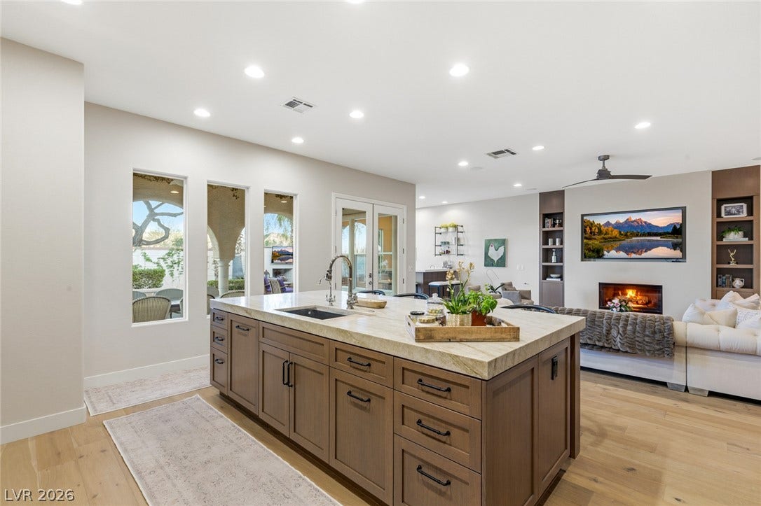 An airy open layout connects the island kitchen to a light-filled living area.