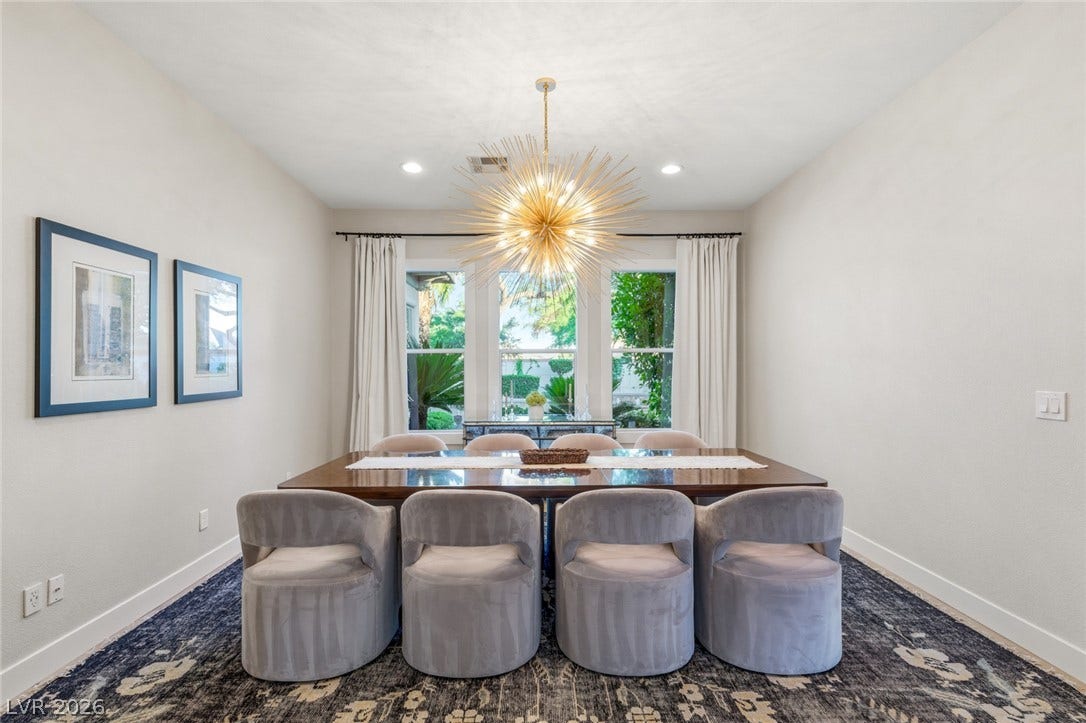 Natural light pours through rear windows into a dining area over wood flooring.