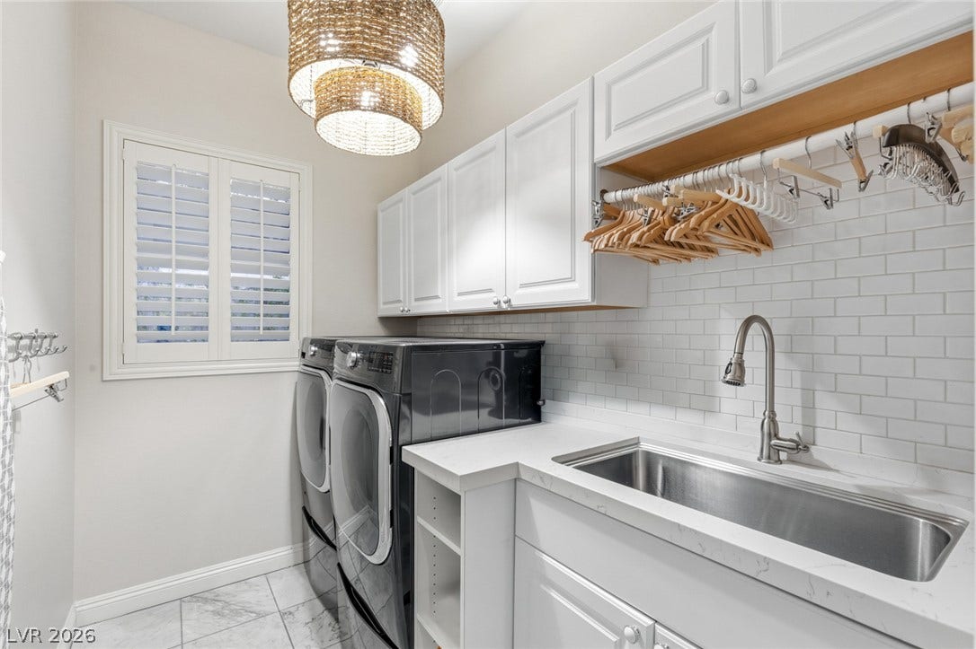 Ample cabinetry and a deep utility sink elevate this functional laundry space.