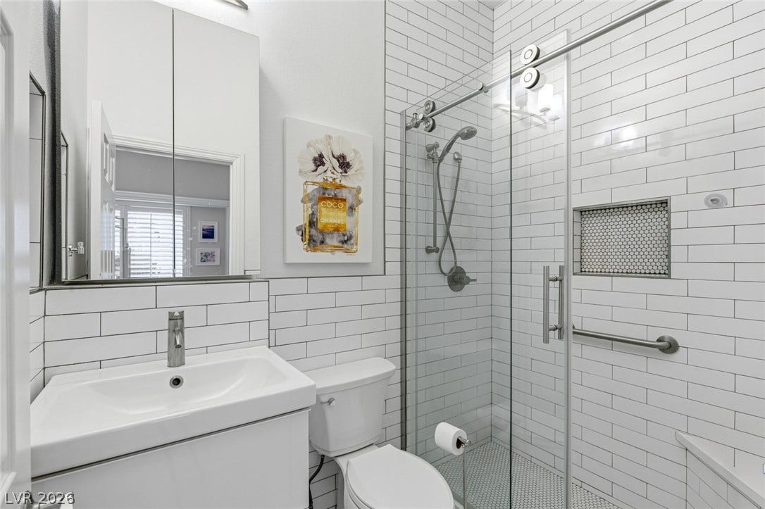 Modern subway tiling and a sleek glass shower enclosure define this contemporary bathroom.